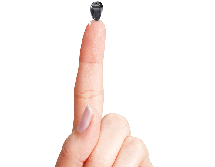 Eine Hand mit nach oben zeigendem Zeigefinger, auf dem sich ein Hörsystem befindet