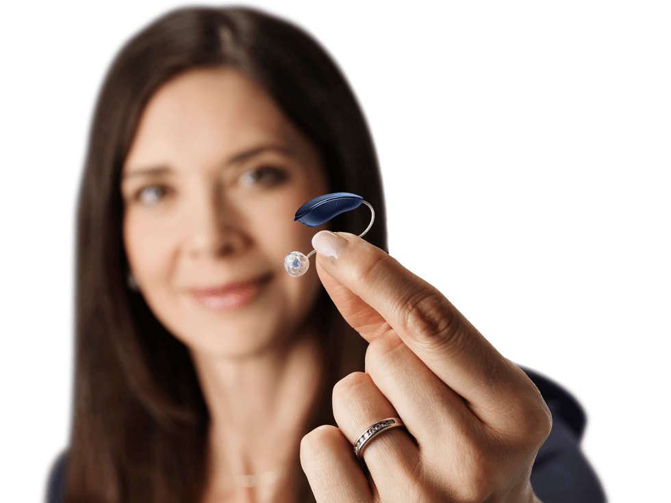 Ein Hörsystem wird von einer Frau in den Vordergrund gehalten.