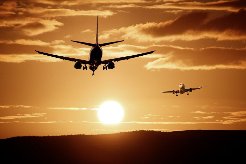 Zwei Flugzeugen in der Luft am Horizont während des Sonnenuntergangs